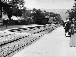 La llegada de un tren a la estación con la salida y entrada de viajeros
