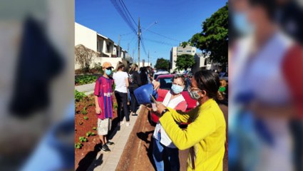 Funcionários do Colégio Professora Júlia Wanderley entregam lanches na fila da vacina em Cascavel