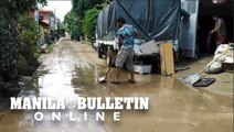 Residents clear mud from their houses following a flood in Davao City