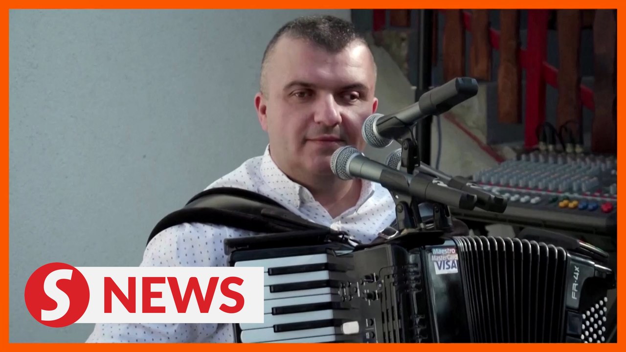 Bosnian musician sticks card reader on accordion
