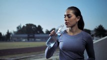 امرأة  تشرب  من  زجاجة  ماء