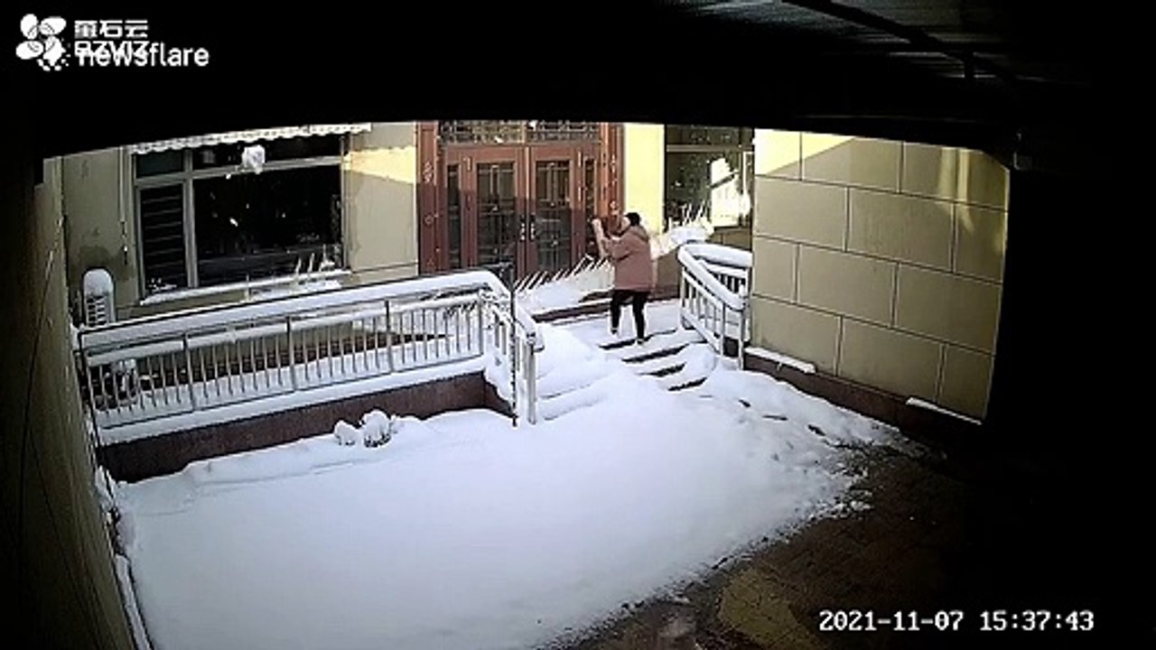 Elle évite de peu une énorme chute de neige tombant du toit