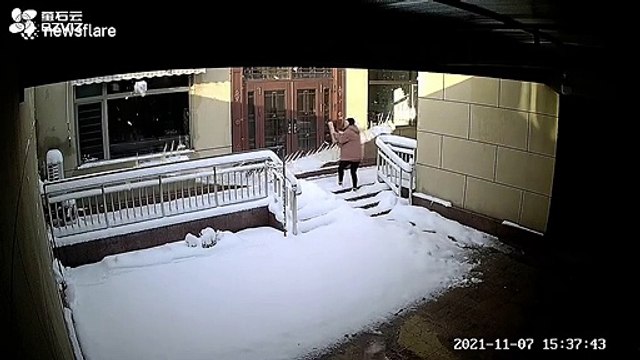 Elle évite de peu une énorme chute de neige tombant du toit