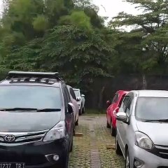 Quand la pluie ne tombe que sur une seule voiture sur ce parking (Indonésie)