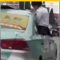 Niña hace tarea apoyándose en techo de taxi en movimiento