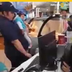 Madre atendiendo heladería con su bebé en brazos