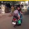 Audaz niño hace tarea mientras su madre conduce una moto en India