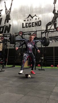 Man Lifts Weights While on Balance Board