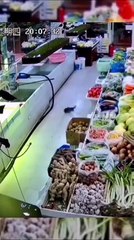 Une femme a une technique quand un poisson sort de son vivier dans un magasin (Chine)