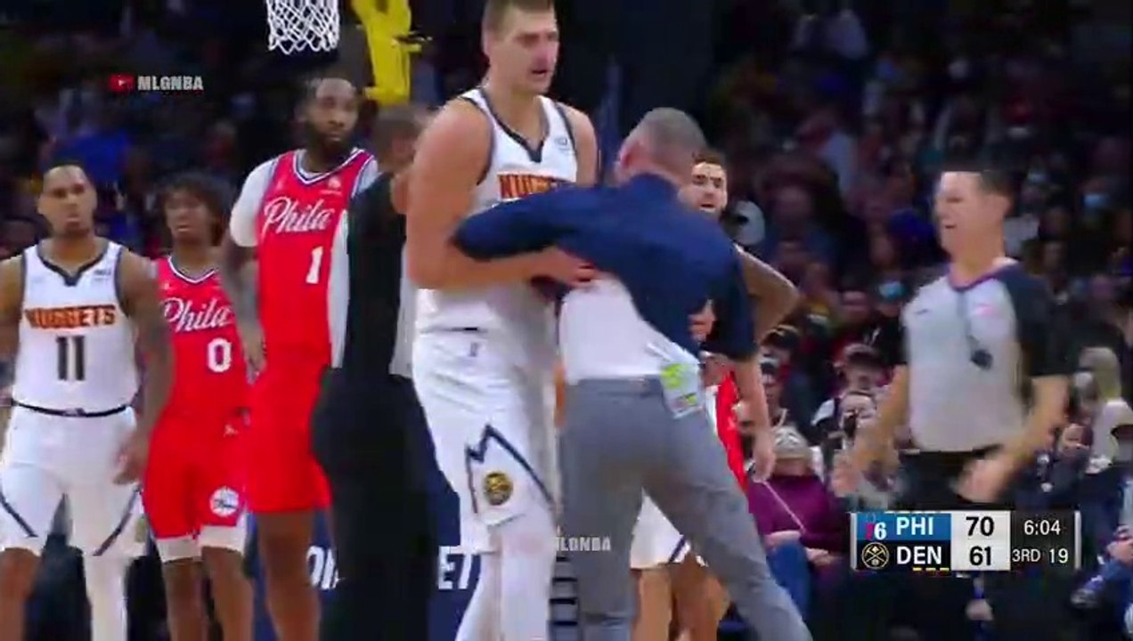 Nikola Jokic steps between his coach and the ref