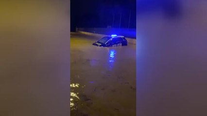 Un coche de la Policía se queda atrapado por una tromba de agua en Cartagena