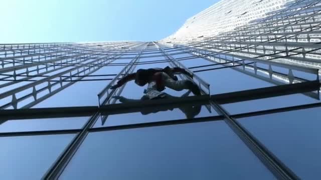 Alain Robert escala sin cuerdas 39 plantas para concienciar sobre el cambio climático