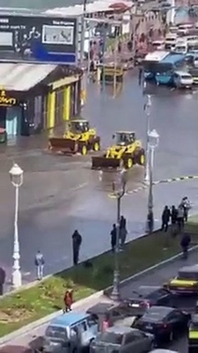 Dos bulldozers limpiando el agua de una carretera inundada !