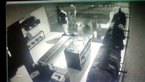 Câmeras de segurança mostram bandidos armados estourando a porta da loja 