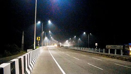 Darkness prevails, overbridge illuminated with floodlights