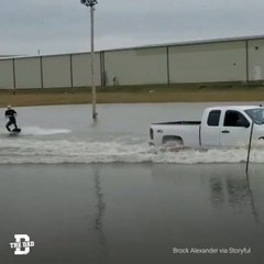 Man Surfs Flooded Parking Lot