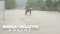 Residents seen carrying a coffin to safety through floodwaters