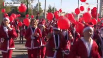 Centenas de pessoas vestidas de Pai Natal correm pelas ruas de Atenas