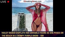 Hailey Bieber displays her enviable figure as she poses on the beach in a skimpy purple bikini - 1br