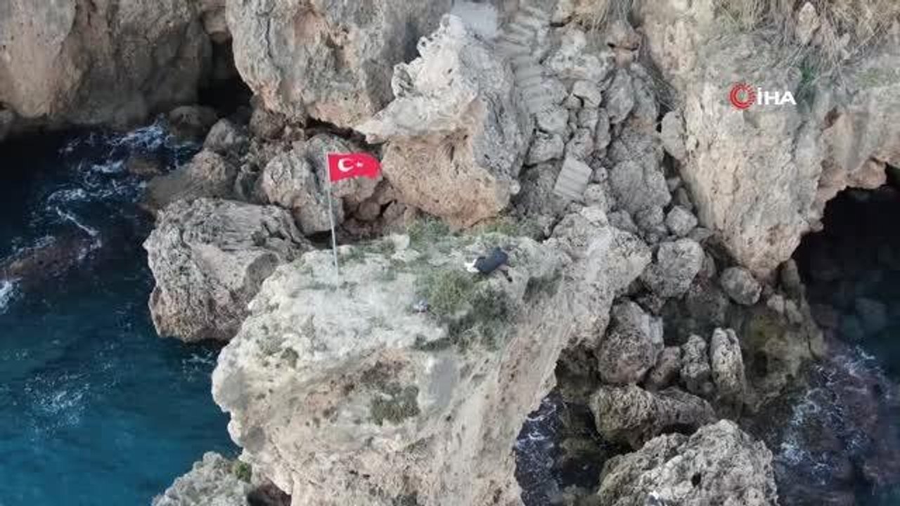 Bayrak sevgisiyle çıktığı 25 metrelik kayalıklarda mahsur kaldı