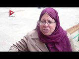 موظف يخرج إلي ناخبة لمساعدتها علي الإدلاء بصوتها باتتخابات الرئاسة في فيصل
