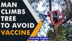 Puducherry: Man climbs tree to avoid vaccination | Watch viral video | Oneindia News