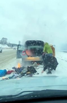 Des passants aident à éteindre un feu de voiture