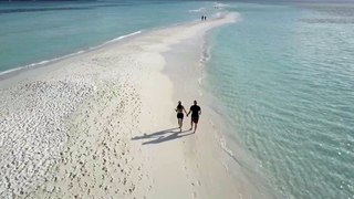 Couple Walking on a Beach Filmed with a Drone