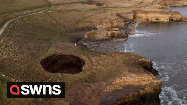 A huge sinkhole has appeared at a coastal beauty spot revealing a hidden underground beach