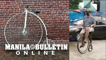 Businessman rides a modern version of the 1870s penny-farthing bicycle in downtown Davao City