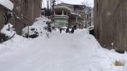 Şemdinli'de çocuklar, bidon, kızak ve poşetlerle kayarak keyifli zaman geçirdi