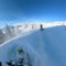 Two Guys Ride Their Snowmobiles Downhill on Snowy Slopes at British Columbia