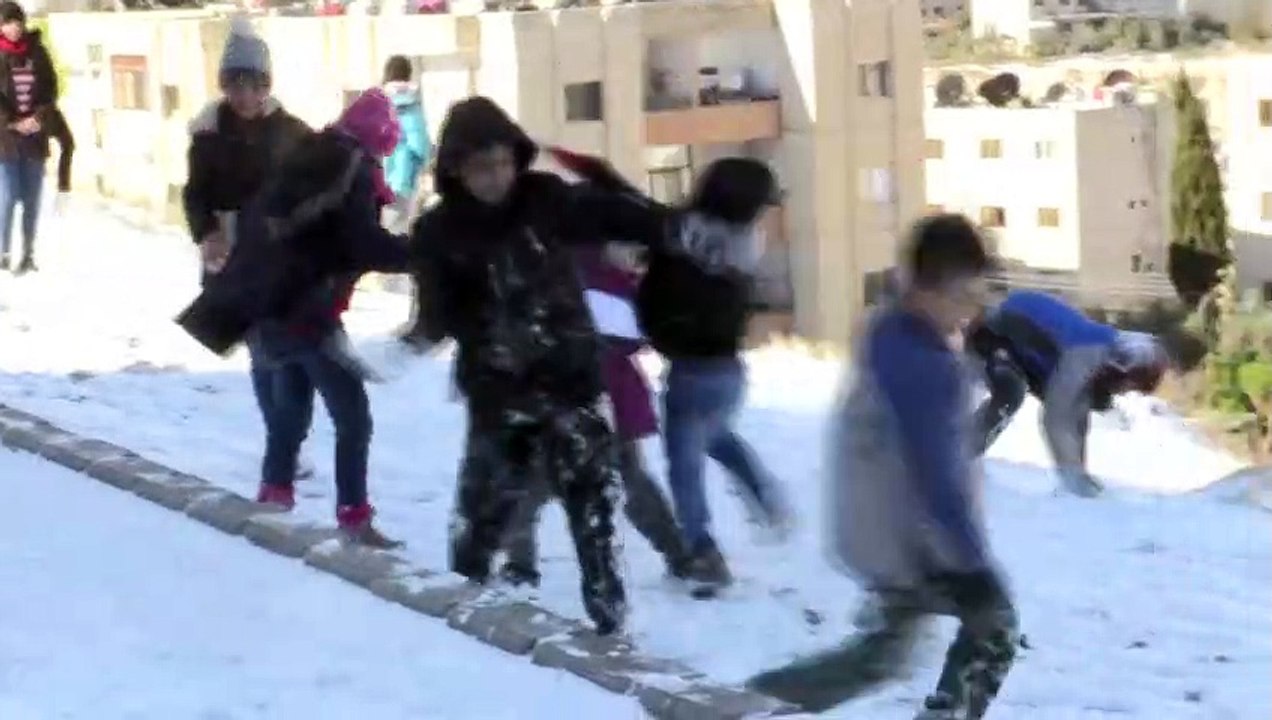 أطفال يستمتعون بالثلوج المتساقطة في دمشق