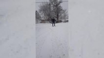 Kar yağışını fırsat bilen öğretmen, okula kayak yaparak gitti