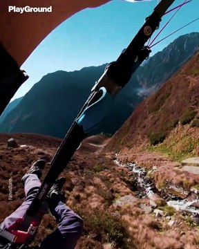 Un piloto de parapente vuela a ras del suelo en los Alpes austriacos