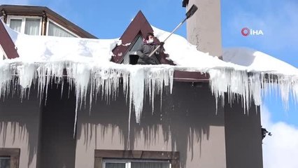 Çatılardaki dev buz sarkıtlarını temizlemek için saatlerce uğraştı