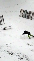 A young man like Sisyphus rolls a ball of snow for a snowman
