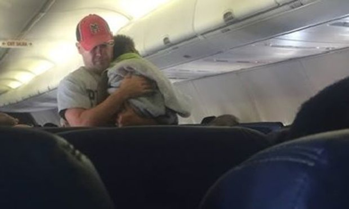 Im Flugzeug nach Atlanta setzt ein Mann ein Zeichen und kümmert sich während des ganzen Fluges um das schreiende Kind einer Schwangeren