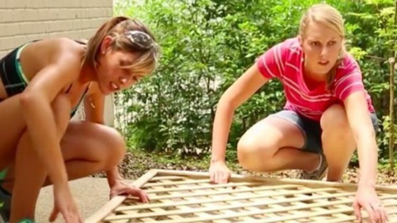 Heimwerker: Zwei junge Frauen bauen sich im Garten eine dekorative Gitterwand zum Schutz vor neugierigen Blicken