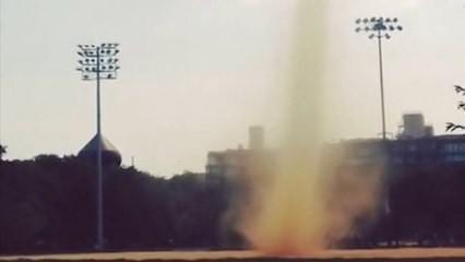 Un tourbillon de poussière surprend des New-yorkais dans un jardin public