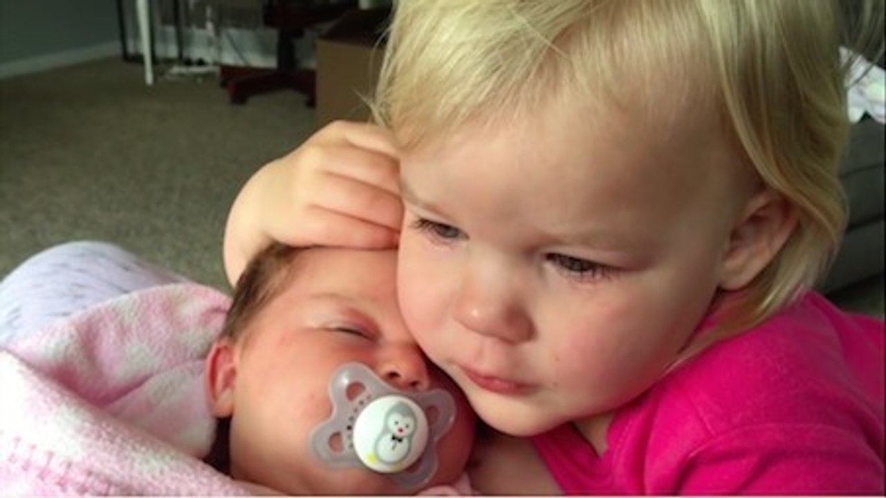 Une petite fille se console en prenant sa petite soeur dans ses bras. C'est tellement adorable !