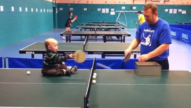 Un bébé joue au ping-pong