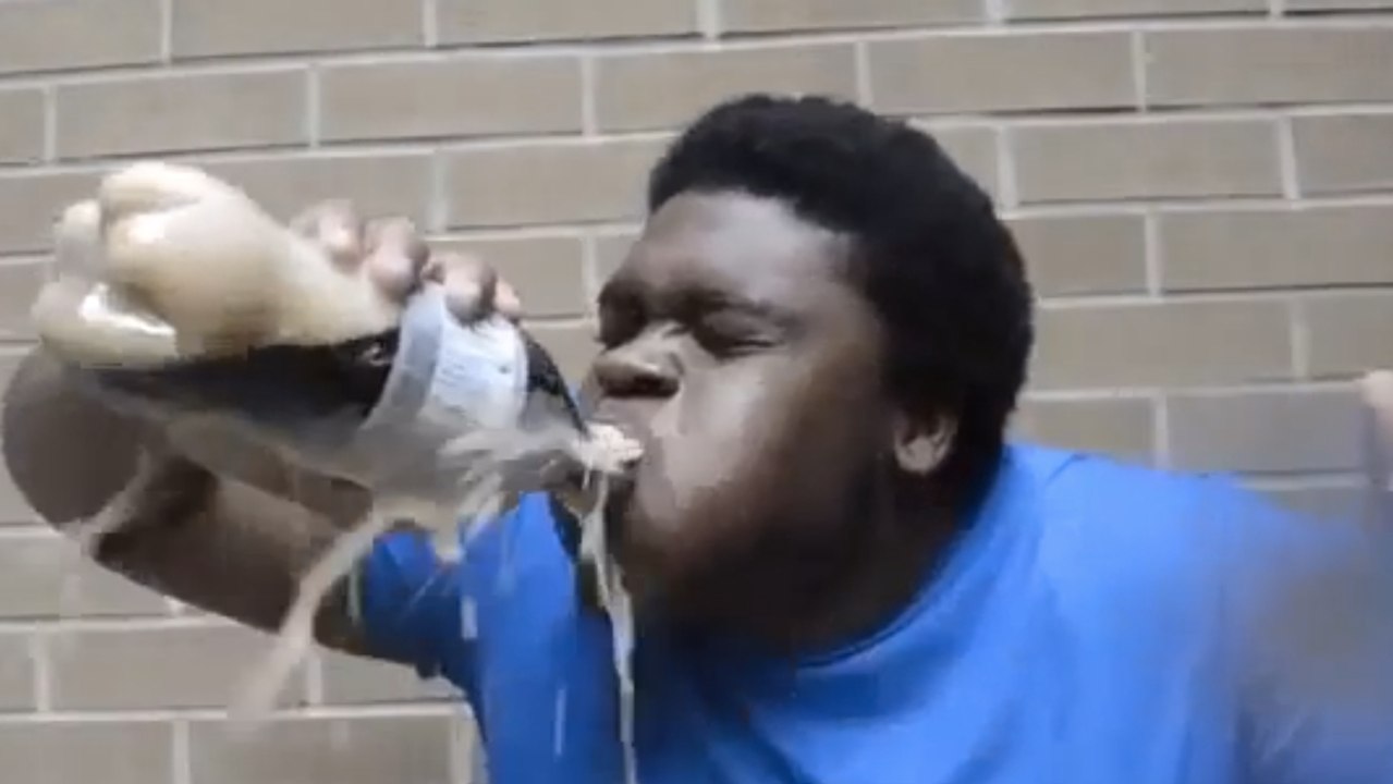 Un homme boit du soda avec des mentos dans la bouche. C'était une très mauvaise idée