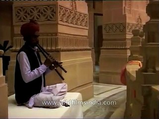 Rajasthani man playing a double flute inside Umaid Bhawan Palace, Jodhpur