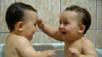 Ces deux bébés s'amusent et rigolent comme des fous dans leur bain. Un moment tout en tendresse