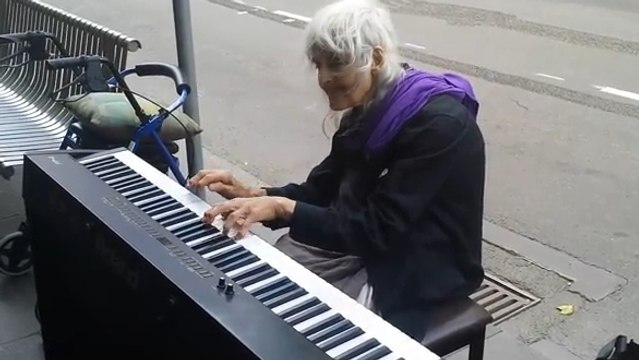 Cette vieille dame joue du piano dans la rue. Un moment très captivant