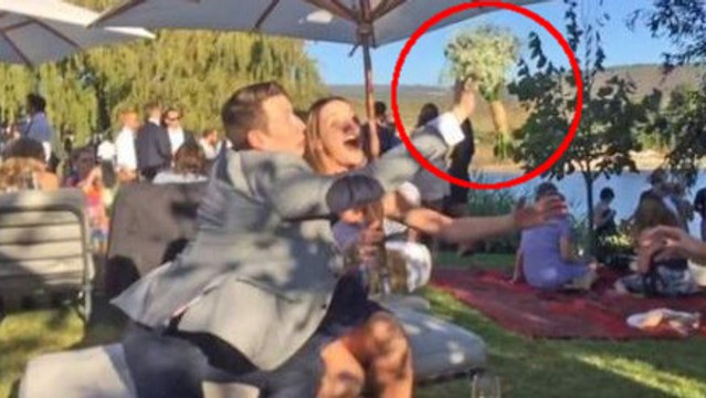 Il empêche sa copine d'attraper le bouquet de la mariée