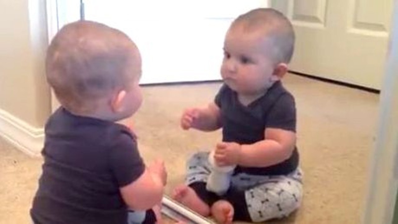 Un bébé découvre sa nouvelle coupe dans le miroir