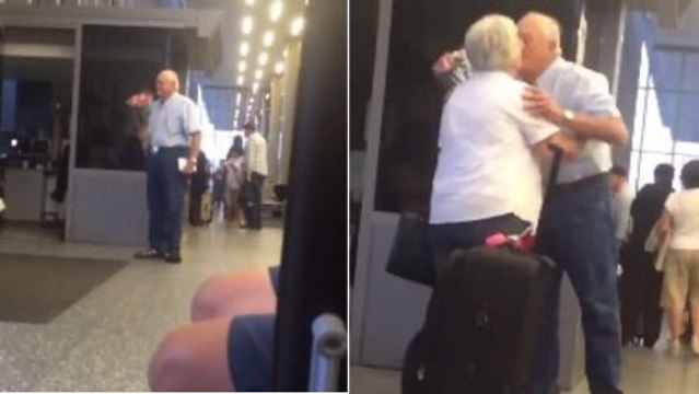 Un vieil homme romantique attend sa femme à l'aéroport avec un bouquet