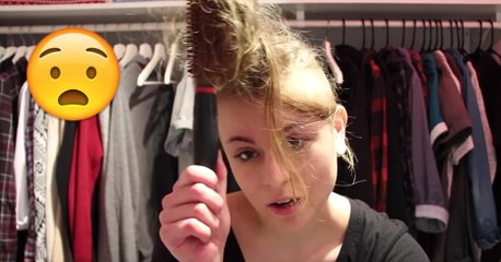 La détresse d'une jeune femme qui coince ses cheveux dans les picots d'une brosse ronde